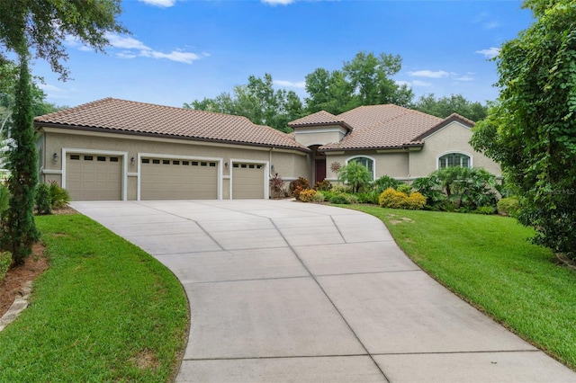 mediterranean / spanish house featuring a garage and a front lawn