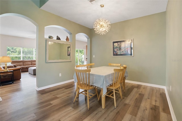 dining room with hardwood / wood-style floors and a notable chandelier