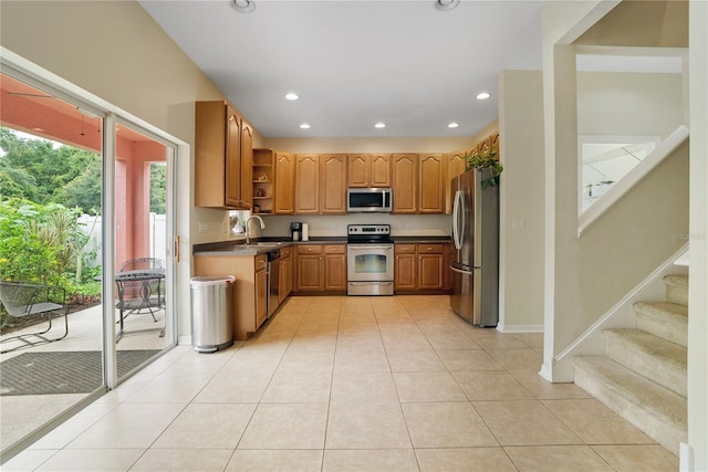 kitchen with appliances with stainless steel finishes, sink, and light tile patterned flooring