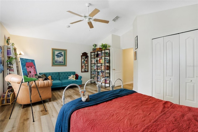 bedroom with ceiling fan, vaulted ceiling, light hardwood / wood-style floors, and a closet