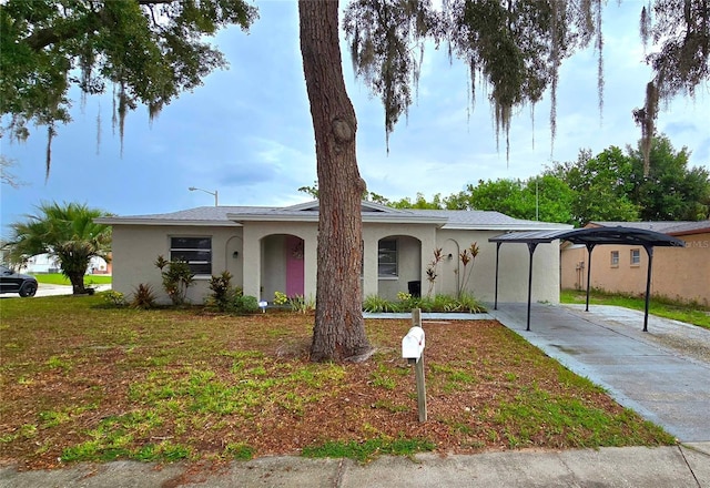 ranch-style home featuring concrete driveway, a front lawn, and stucco siding