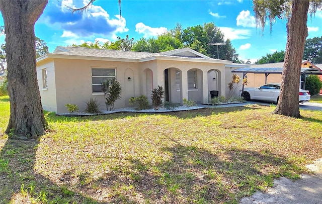 view of front of property featuring a front yard and a carport