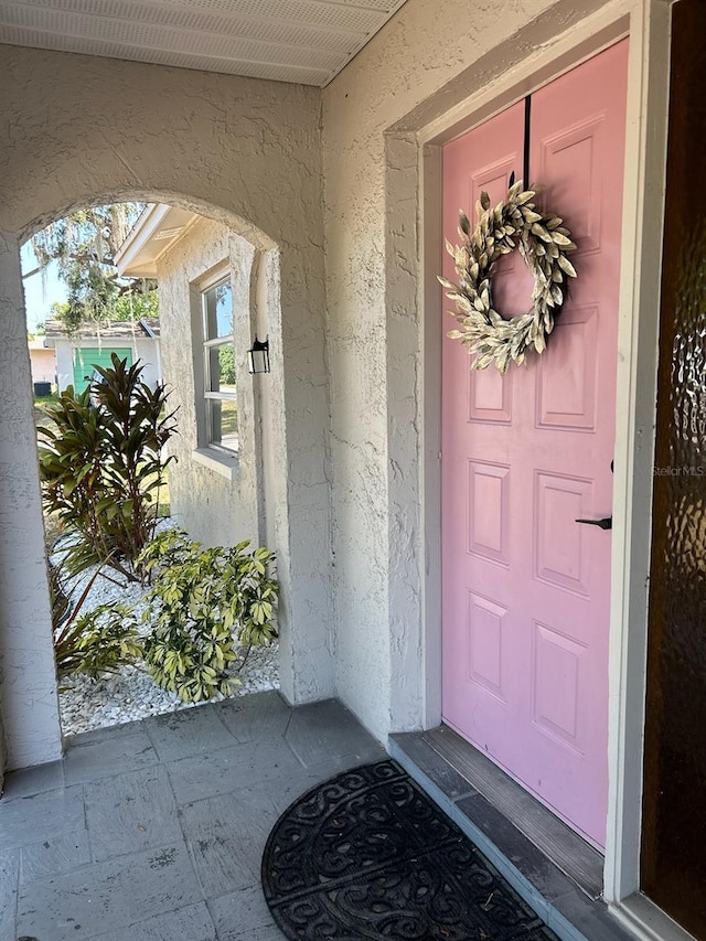 view of exterior entry with stucco siding