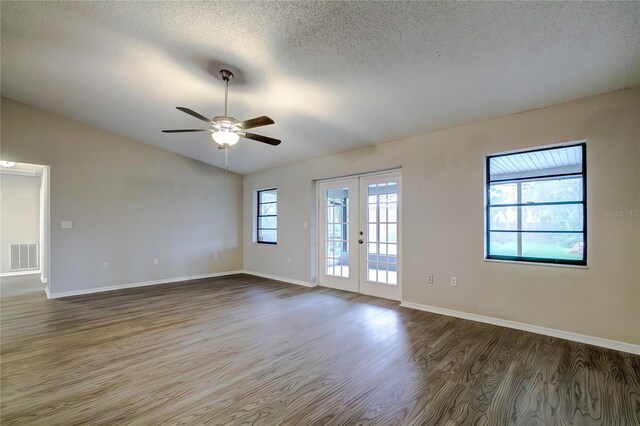 unfurnished room featuring ceiling fan, dark hardwood / wood-style flooring, a textured ceiling, and french doors