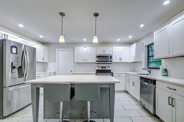 kitchen with white cabinets, stainless steel appliances, and hanging light fixtures