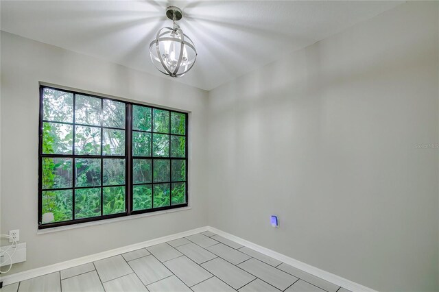empty room with an inviting chandelier and a wealth of natural light