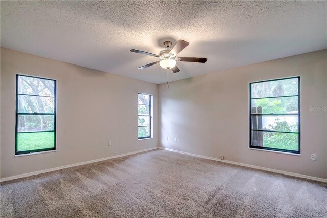 unfurnished room with a textured ceiling, carpet floors, and ceiling fan