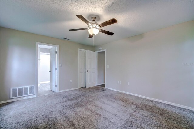 carpeted empty room with ceiling fan and a textured ceiling