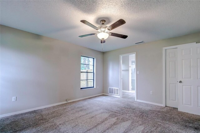 carpeted empty room featuring ceiling fan and a textured ceiling