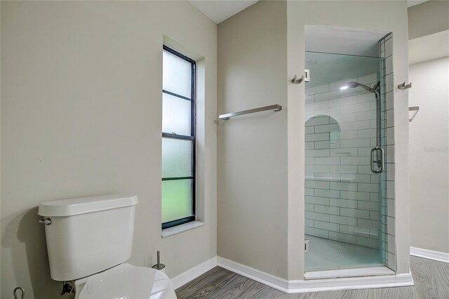 bathroom featuring walk in shower, toilet, and hardwood / wood-style flooring