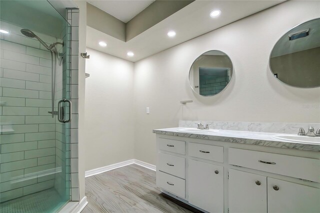 bathroom with hardwood / wood-style flooring, vanity, and an enclosed shower