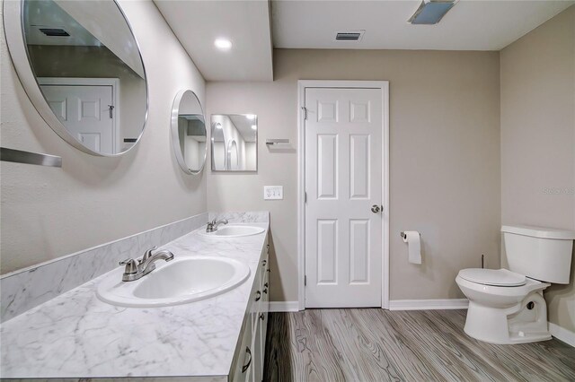 bathroom featuring vanity, hardwood / wood-style flooring, and toilet