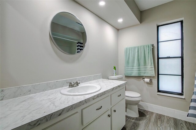 bathroom with vanity, wood-type flooring, and toilet