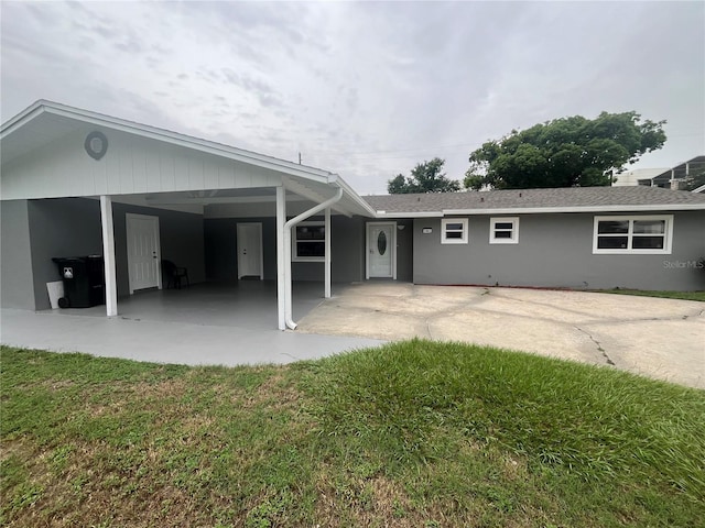 rear view of property featuring a carport and a lawn