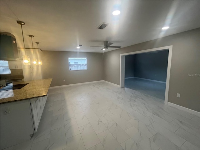 unfurnished living room with ceiling fan