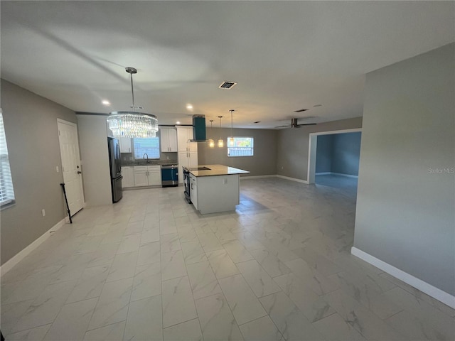 kitchen featuring stainless steel refrigerator, a center island, pendant lighting, extractor fan, and white cabinets