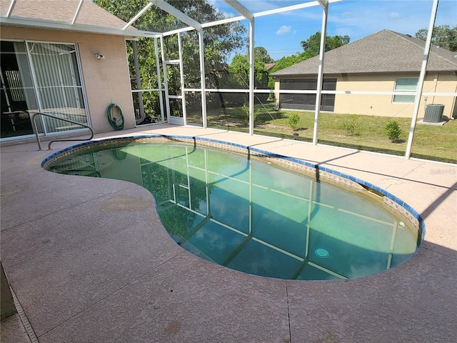 view of pool with glass enclosure, central AC, and a patio