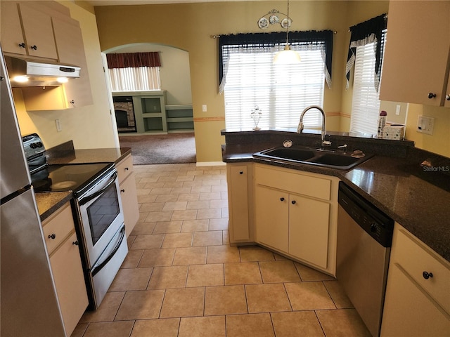 kitchen with light tile patterned floors, appliances with stainless steel finishes, sink, and a wealth of natural light