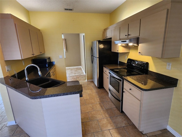 kitchen with appliances with stainless steel finishes, sink, a textured ceiling, light tile patterned floors, and kitchen peninsula