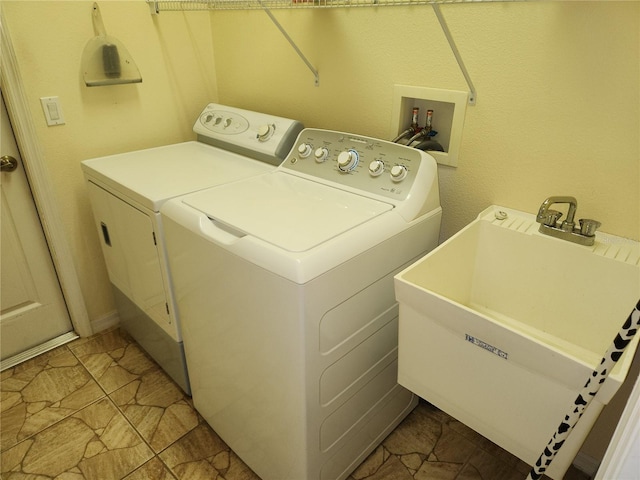 laundry area featuring light tile patterned flooring, sink, and washer and clothes dryer