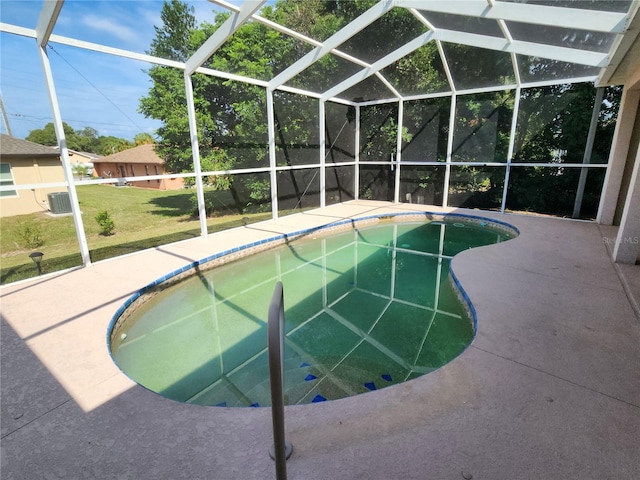 view of pool featuring glass enclosure and a patio area