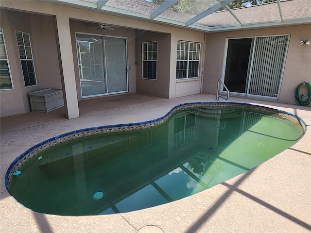 view of swimming pool featuring ceiling fan, a lanai, and a patio