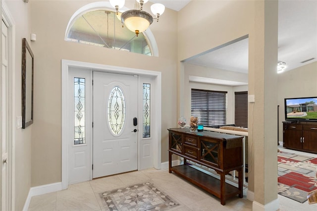 tiled foyer with an inviting chandelier