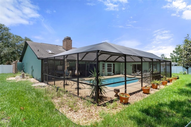 view of pool featuring a yard, a patio area, and glass enclosure