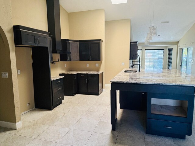 6096 Kinlock Ave, Spring Hill, FL 34608 - kitchen with ventilation hood, dark cabinets, light stone countertops, and a sink