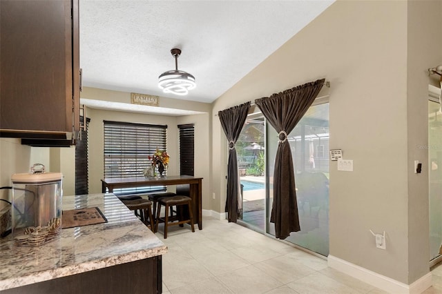 6096 Kinlock Ave, Spring Hill, FL 34608 - interior space with baseboards, a textured ceiling, lofted ceiling, and light tile patterned flooring