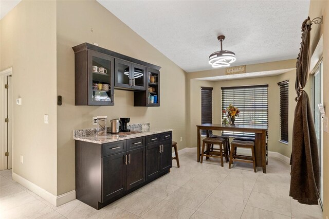 6096 Kinlock Ave, Spring Hill, FL 34608 - bar with light tile patterned floors, baseboards, a textured ceiling, and lofted ceiling