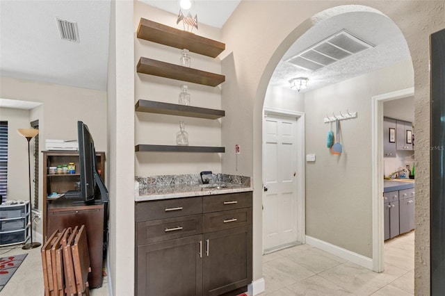 6096 Kinlock Ave, Spring Hill, FL 34608 - bar featuring visible vents, arched walkways, baseboards, and light tile patterned floors