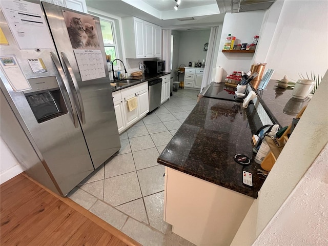 kitchen with light tile patterned floors, appliances with stainless steel finishes, sink, and white cabinetry