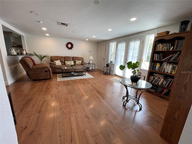 living room featuring french doors and light hardwood / wood-style flooring