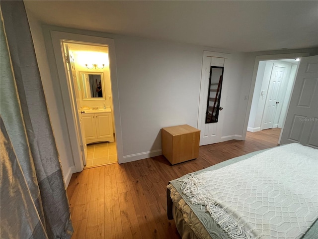 bedroom featuring ensuite bathroom and light wood-type flooring