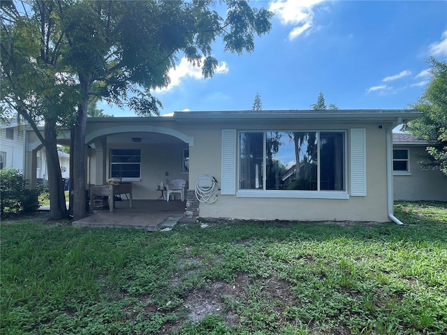 rear view of property featuring a patio area and a yard