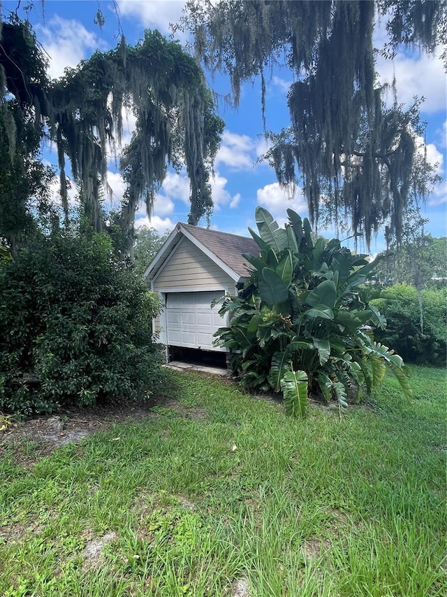 view of side of home featuring a garage and a lawn