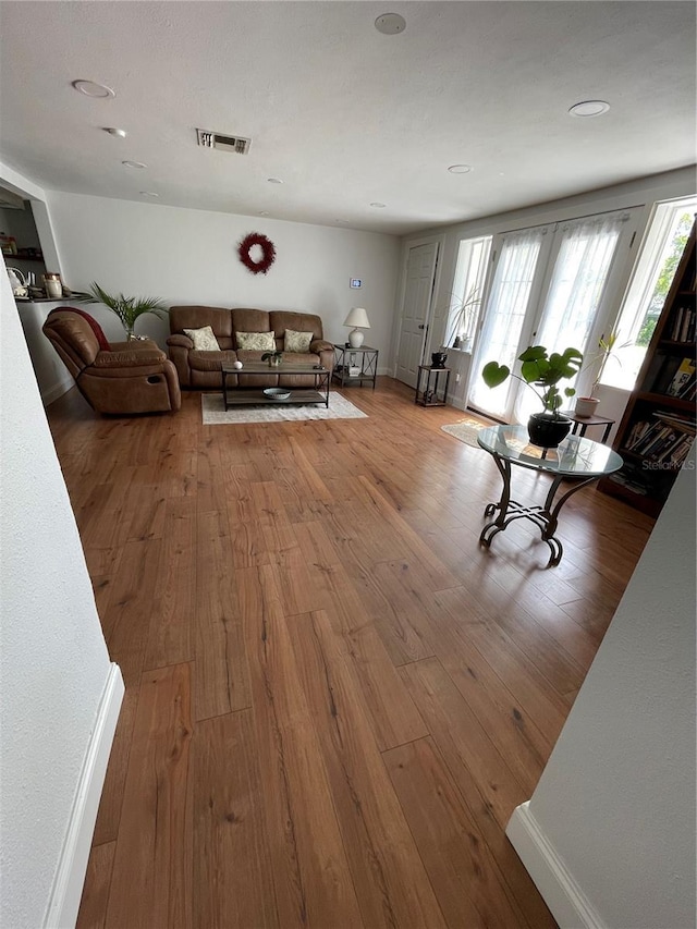 unfurnished living room with french doors and light hardwood / wood-style floors