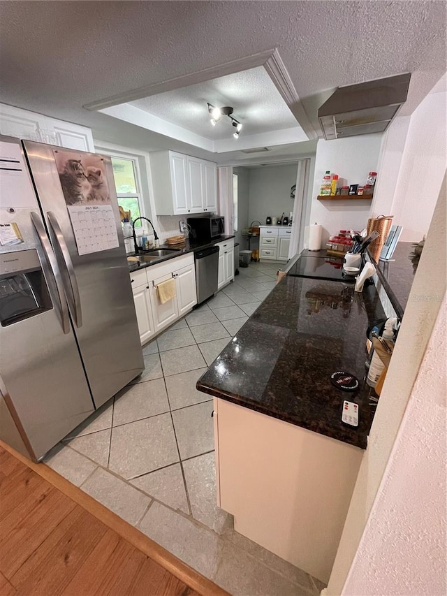 kitchen with light tile patterned floors, white cabinetry, appliances with stainless steel finishes, a textured ceiling, and sink