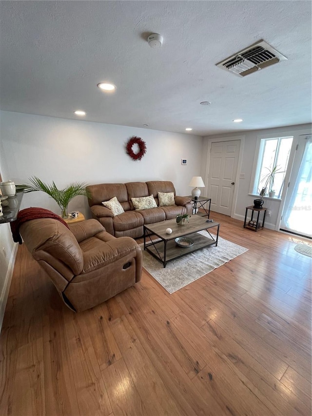 living room featuring a textured ceiling and light wood-type flooring