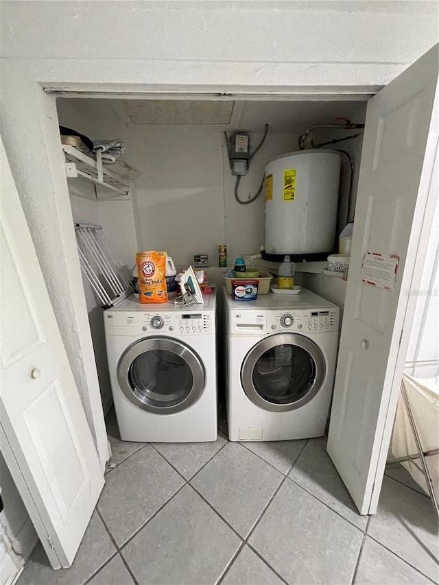 clothes washing area with water heater, light tile patterned flooring, and washing machine and dryer