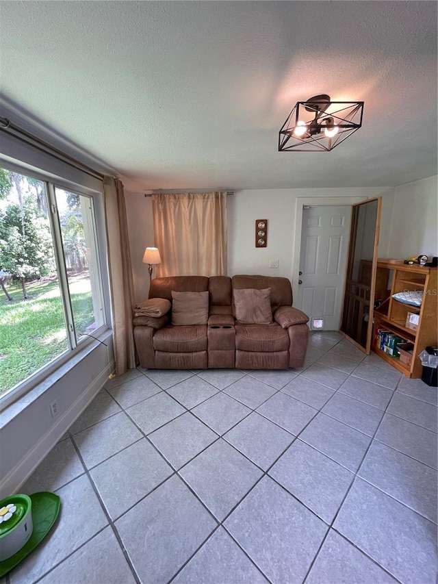 living room with a textured ceiling and light tile patterned flooring