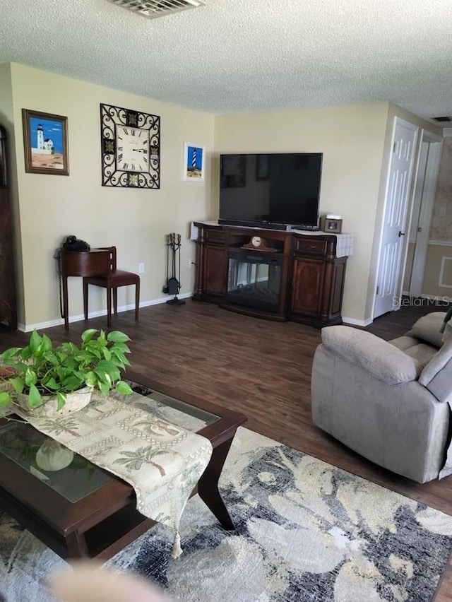 living room featuring dark hardwood / wood-style floors and a textured ceiling