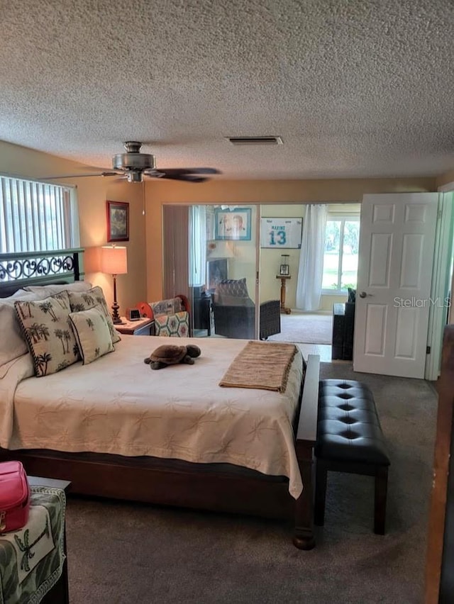 carpeted bedroom with a textured ceiling and ceiling fan