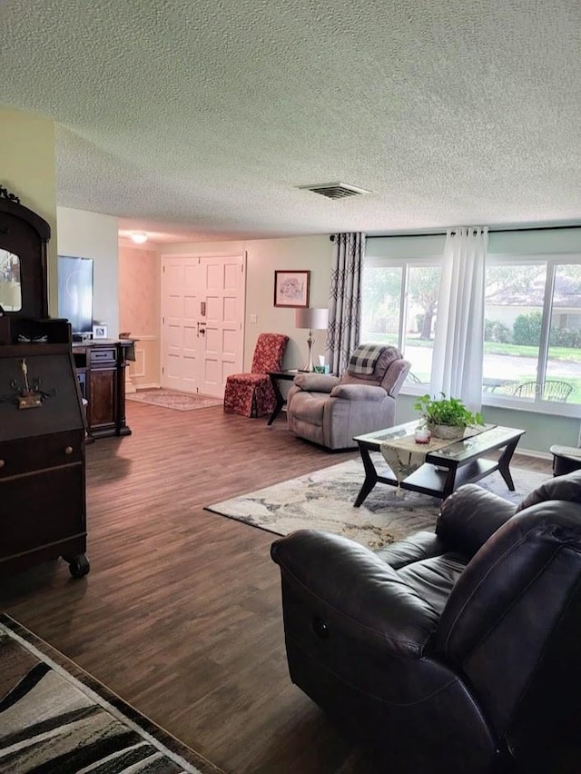 living room with dark wood-type flooring and a textured ceiling