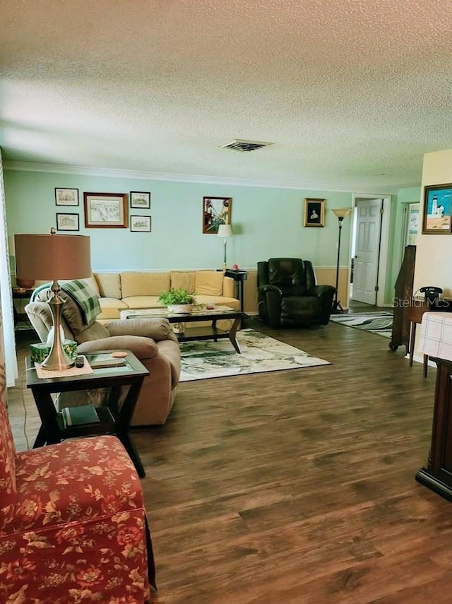 living room featuring dark hardwood / wood-style floors, crown molding, and a textured ceiling