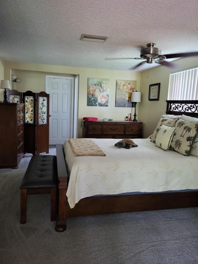 bedroom with ceiling fan, carpet floors, and a textured ceiling