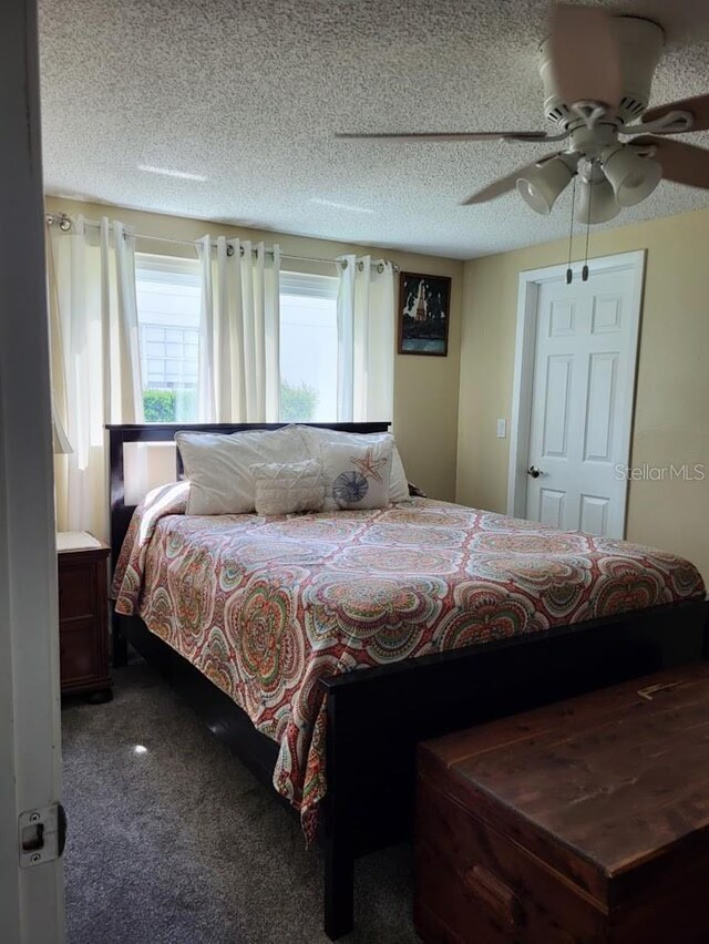 bedroom featuring ceiling fan, carpet floors, and a textured ceiling