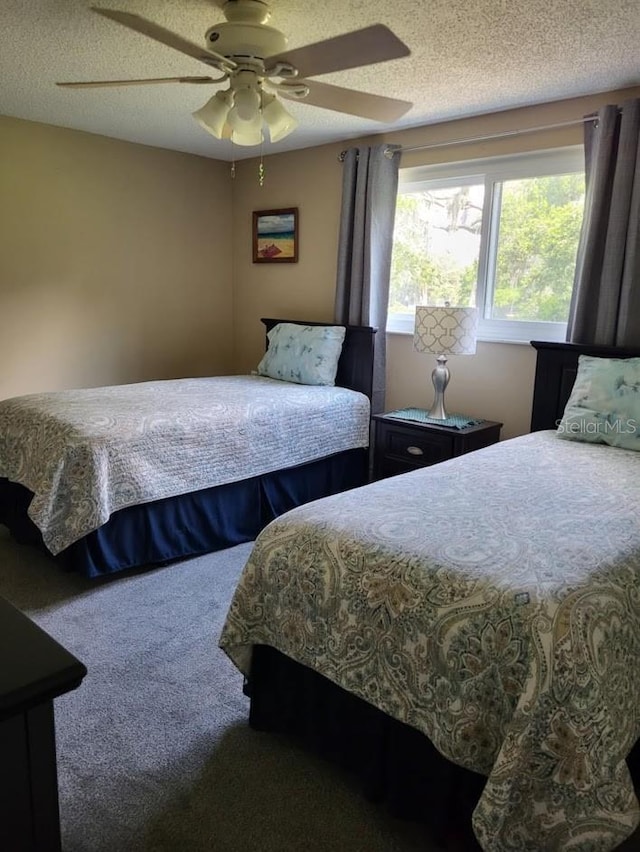 bedroom featuring a textured ceiling, ceiling fan, and carpet flooring