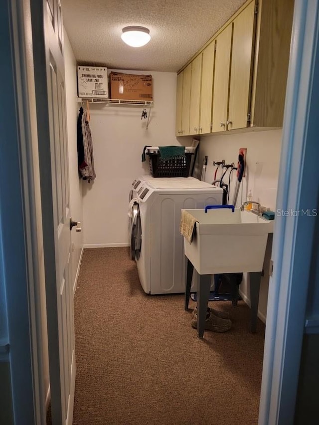 clothes washing area featuring washing machine and dryer, carpet floors, cabinets, and a textured ceiling